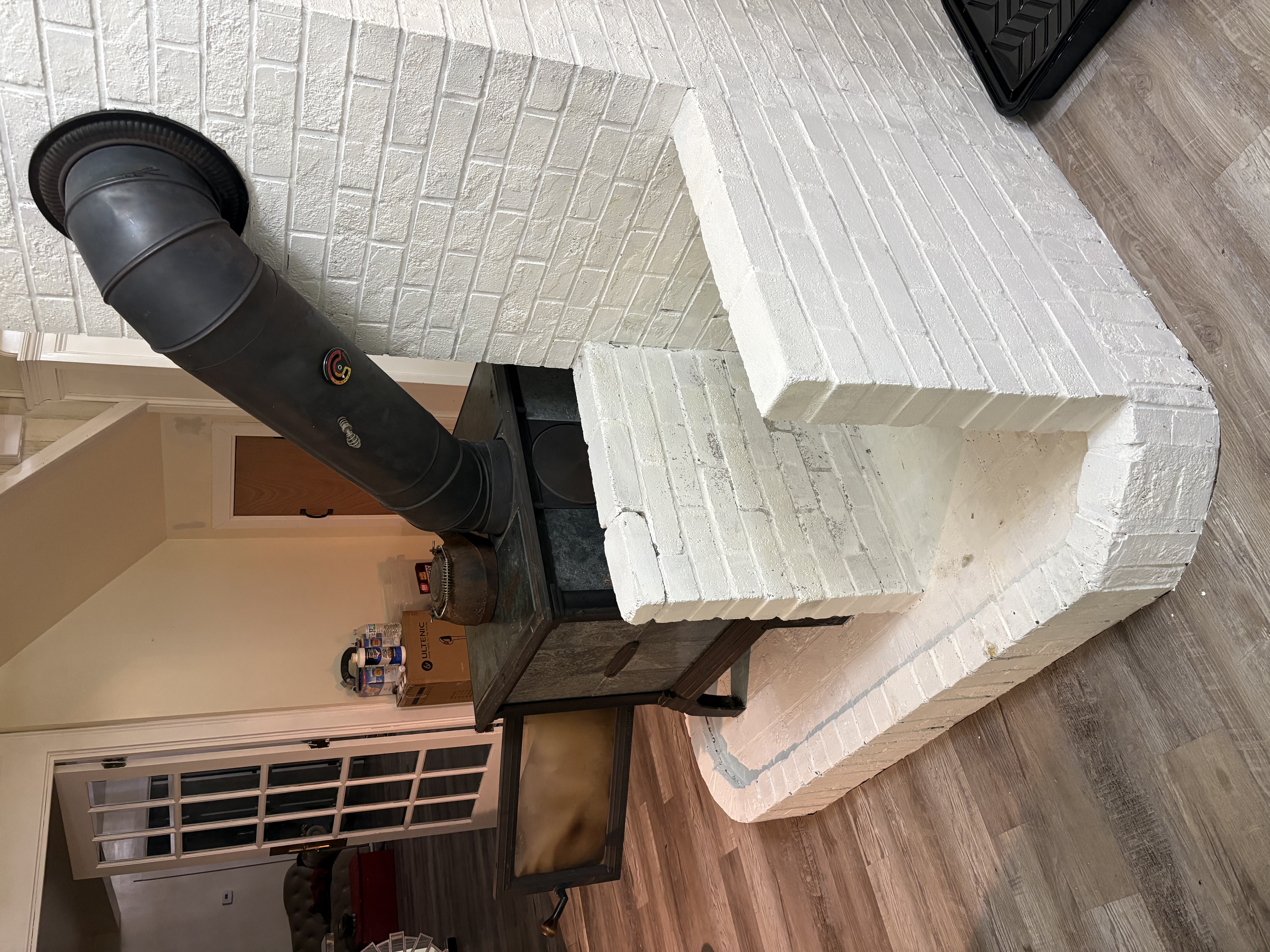 Wood stove painted brick surround and LVP flooring NH